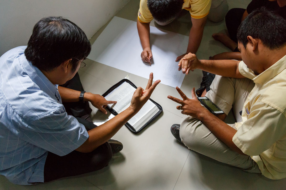 Group of men discussing Scripture through Thai Sign Language.